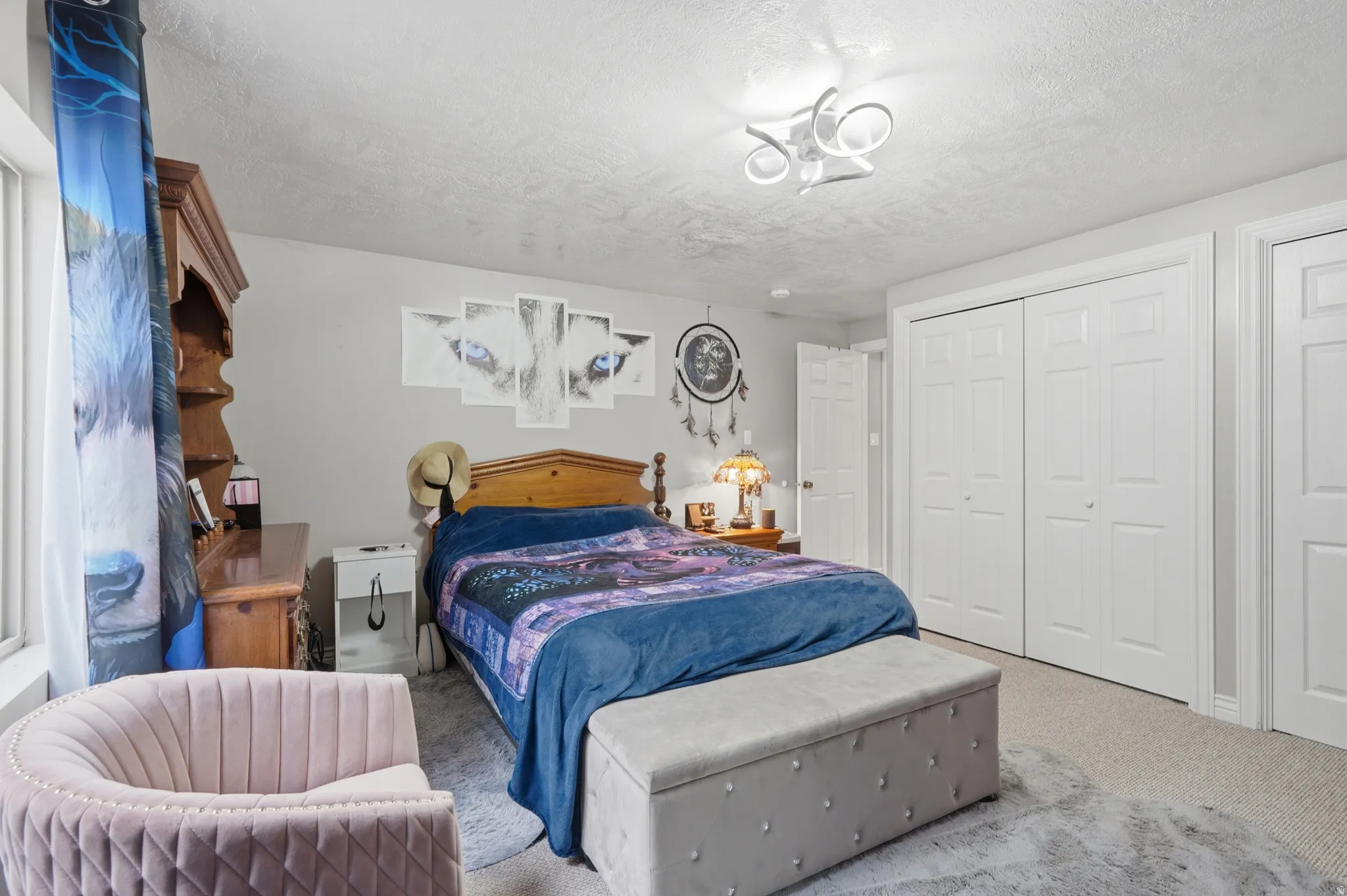 Carpeted room featuring a modern ceiling fixture, white bi-fold closet doors, and white paneled doors