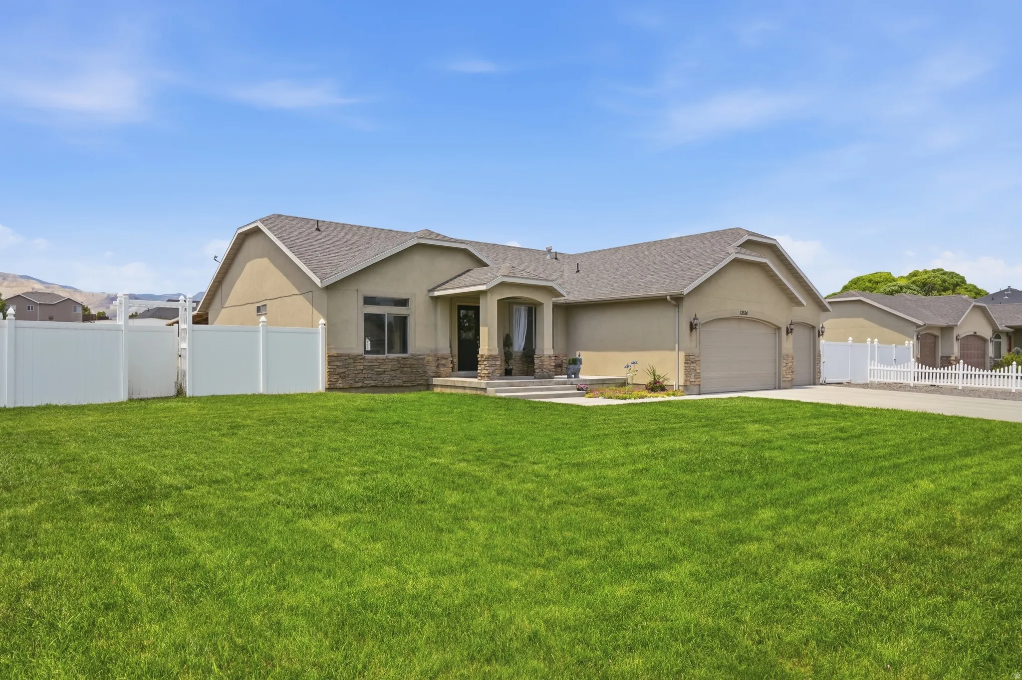 Expansive front lawn with a stucco and stone exterior