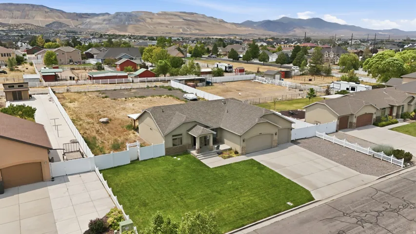 Single-story residence featuring an attached two-car garage, concrete driveway, and a front lawn