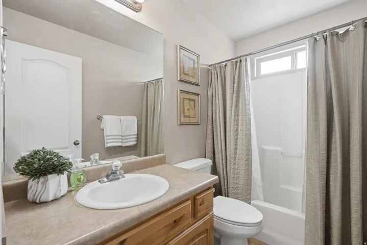 Bathroom featuring a vanity with a laminate countertop, an undermount sink, and a wood-finish cabinet