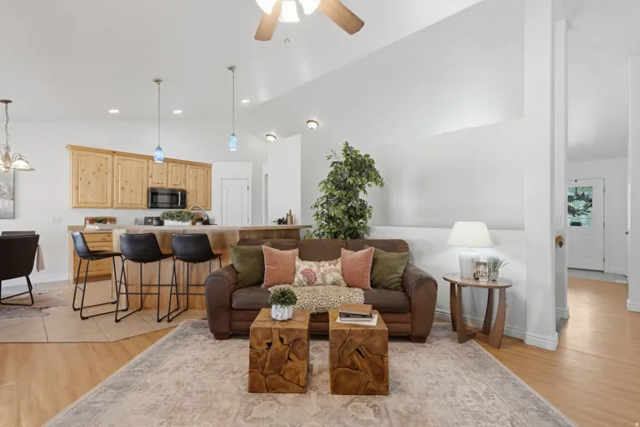 Open-concept living area featuring light wood-finish flooring, a vaulted ceiling, and recessed lighting