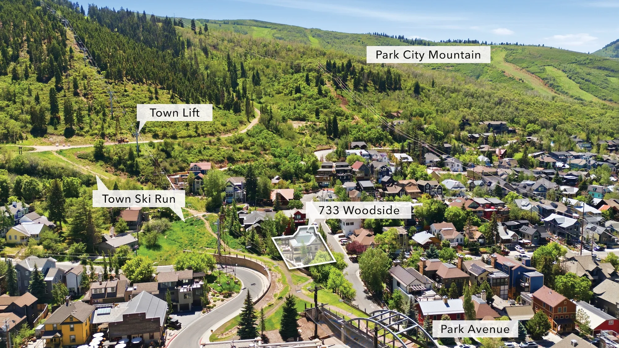 Aerial perspective showcasing a residential area nestled at the base of a verdant mountain