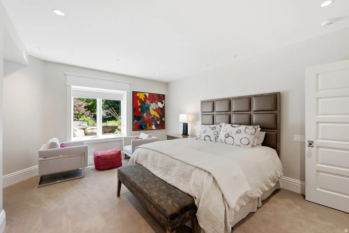 Carpeted room featuring a window with a garden view, a paneled door, recessed lighting, and crown molding