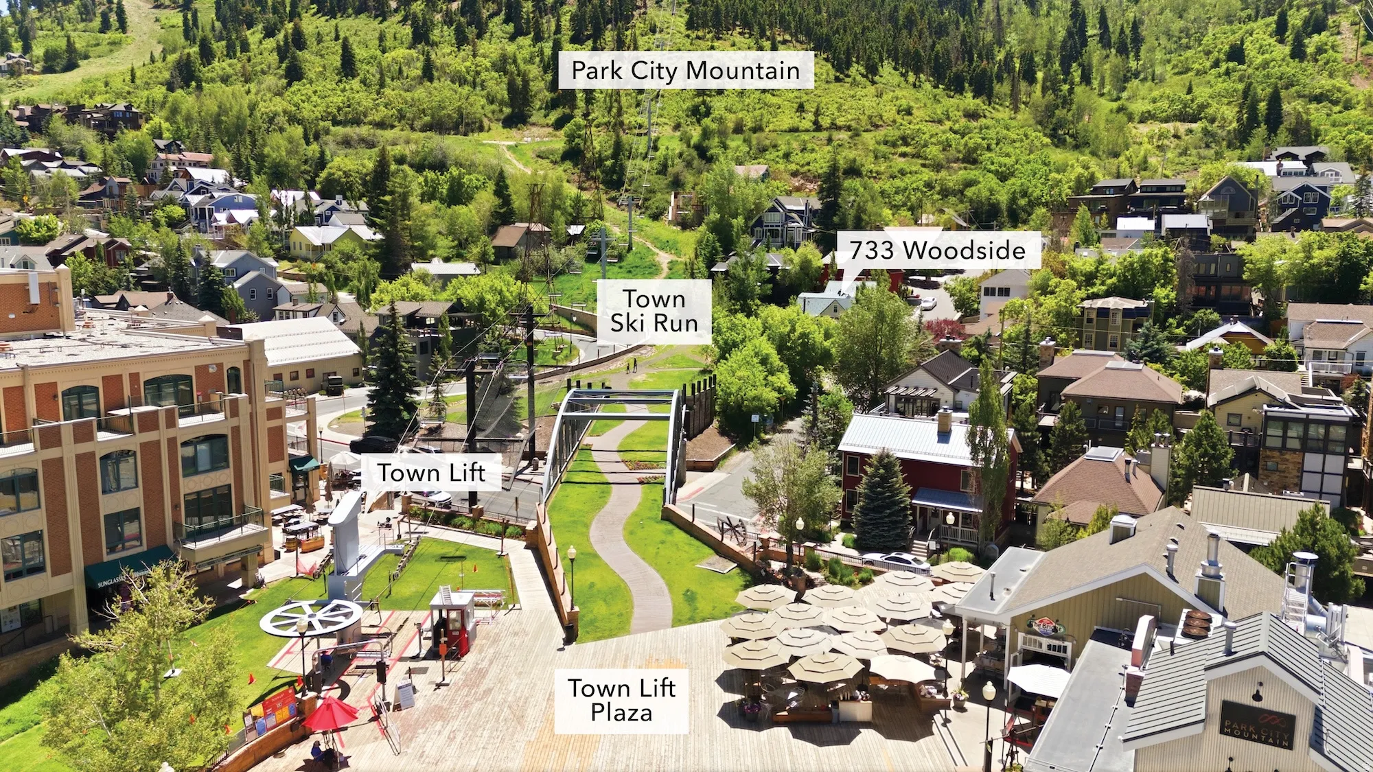 Aerial overview showcasing the property at 733 Woodside, surrounded by a vibrant mountain landscape