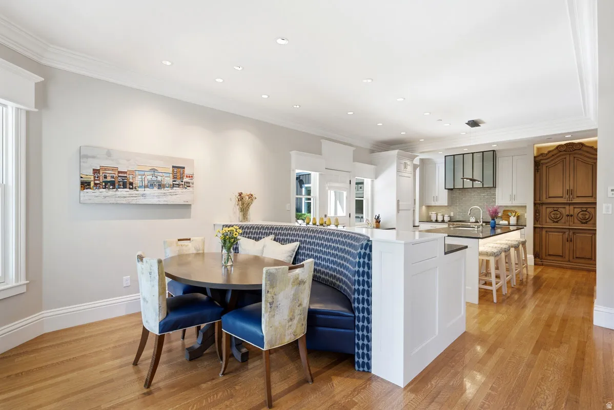 Open-concept living area featuring wood-finish flooring, recessed lighting, and a built-in dining banquette