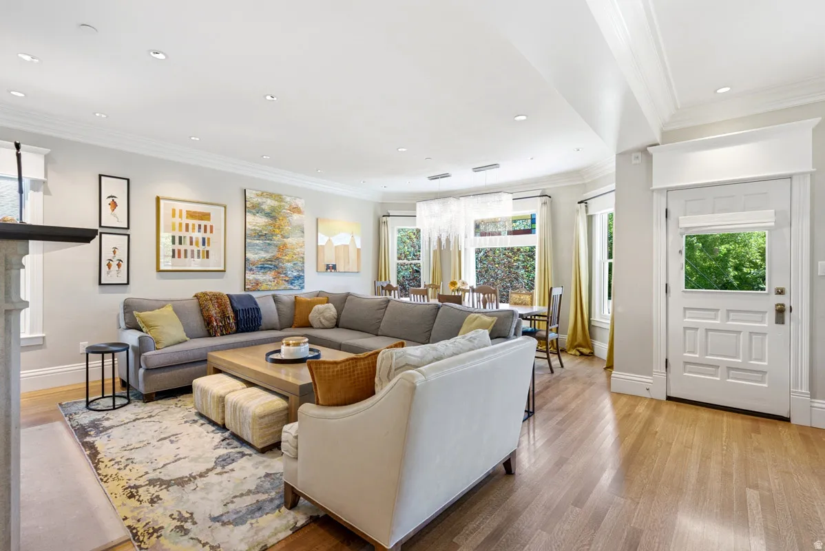 Open-concept living area with wood-finish flooring, recessed lighting, and crown molding
