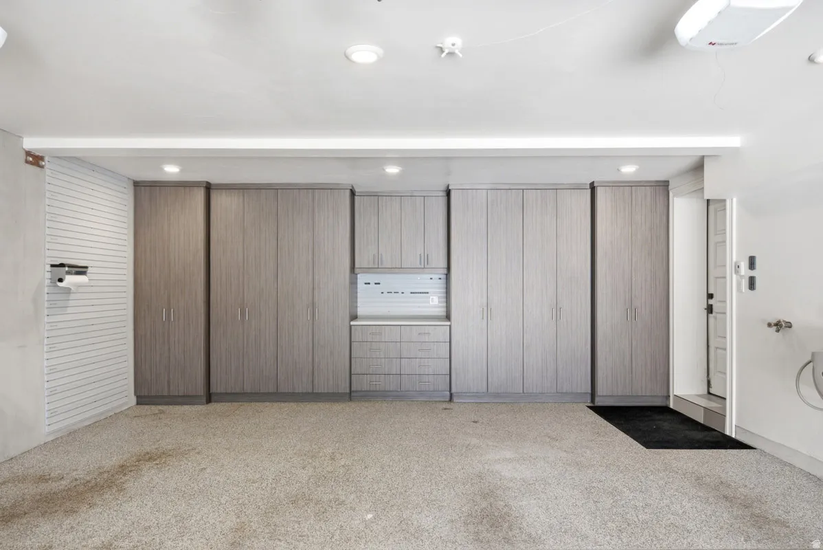 Integrated garage storage system featuring multiple full-height cabinets, base cabinets with drawers, and upper cabinetry