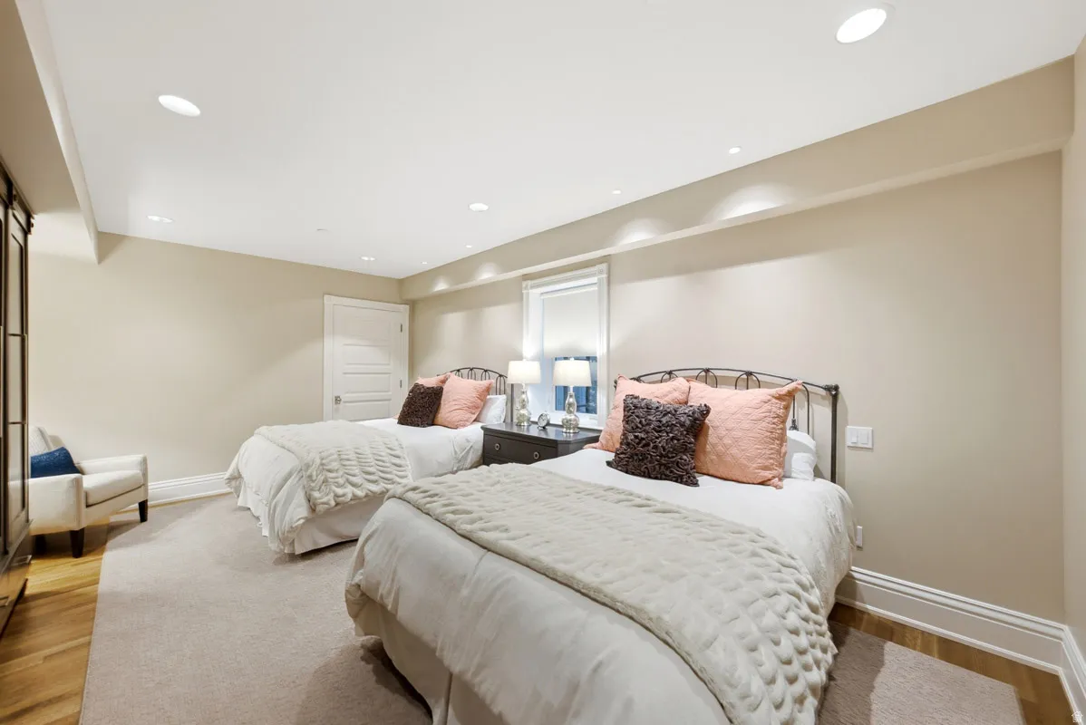 Recessed lighting illuminates neutral-toned walls and a plush carpeted floor