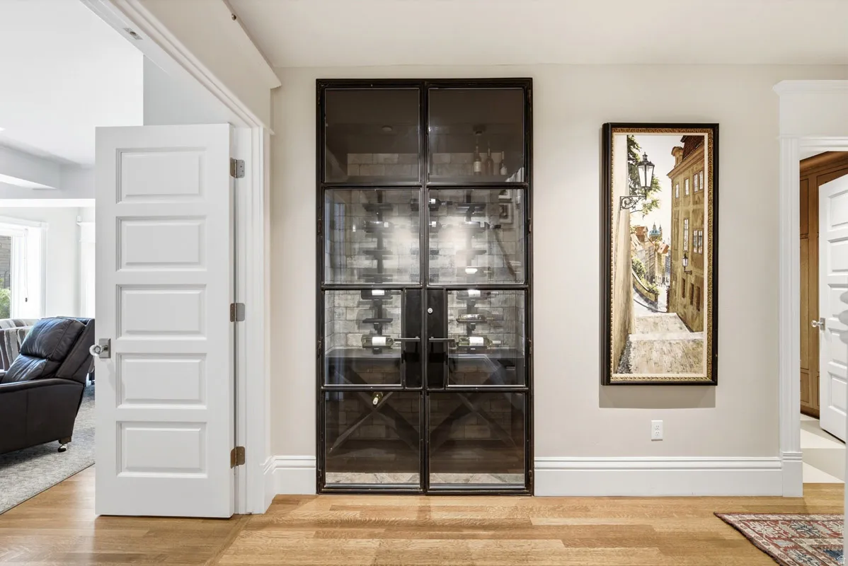 Custom wine cellar with glass and metal doors, featuring interior brick-style wall treatment and built-in bottle racks