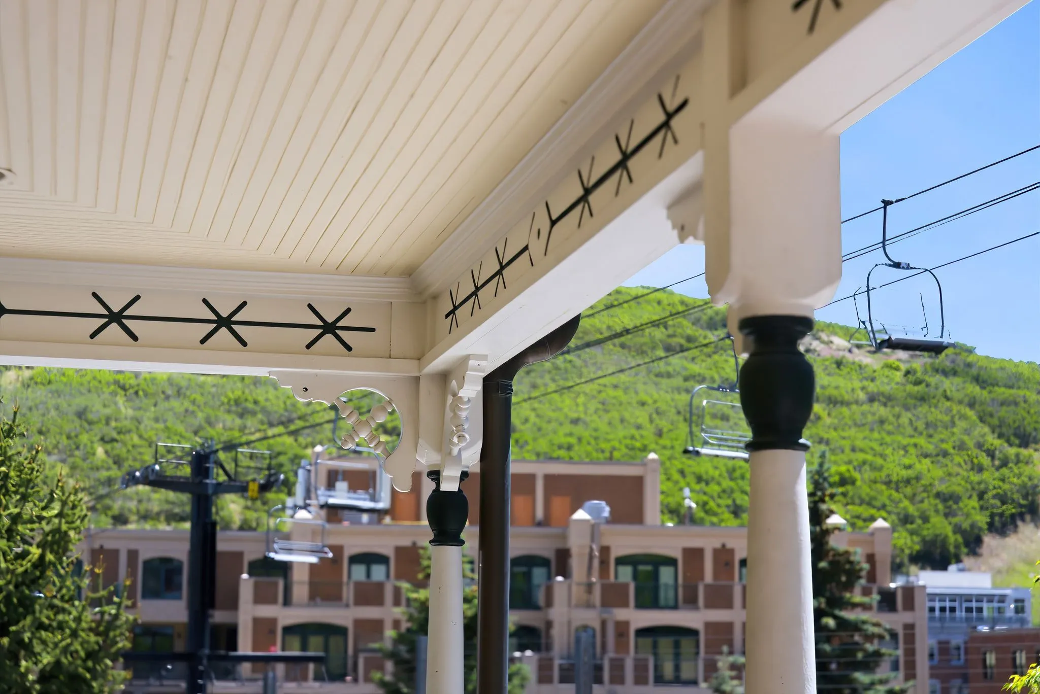 Covered porch featuring beadboard ceiling, decorative brackets, and turned columns
