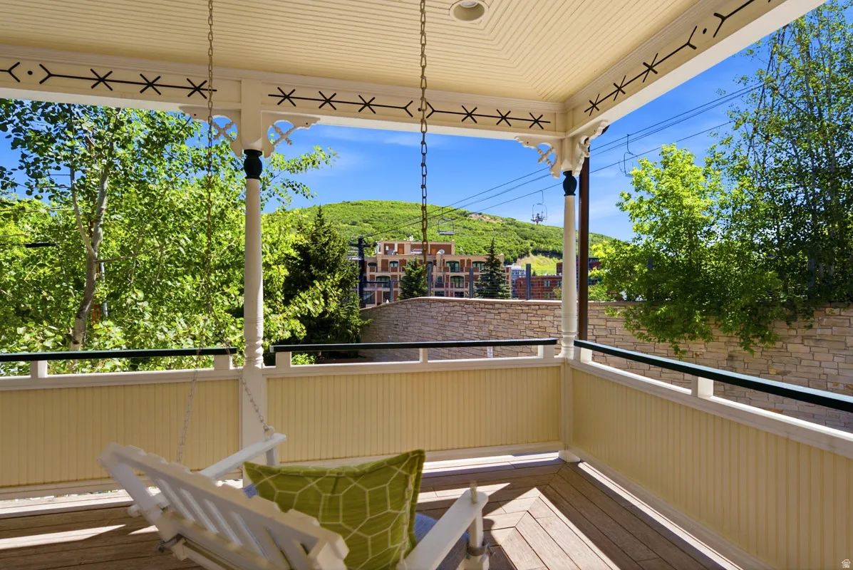 Covered porch featuring a wood-finish floor, beadboard railing, and decorative trim