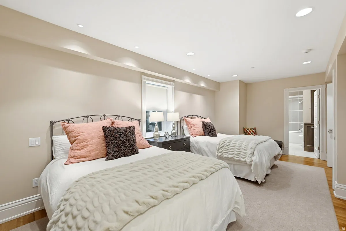 Bedroom featuring recessed lighting, a window with roller shade, and neutral wall tones
