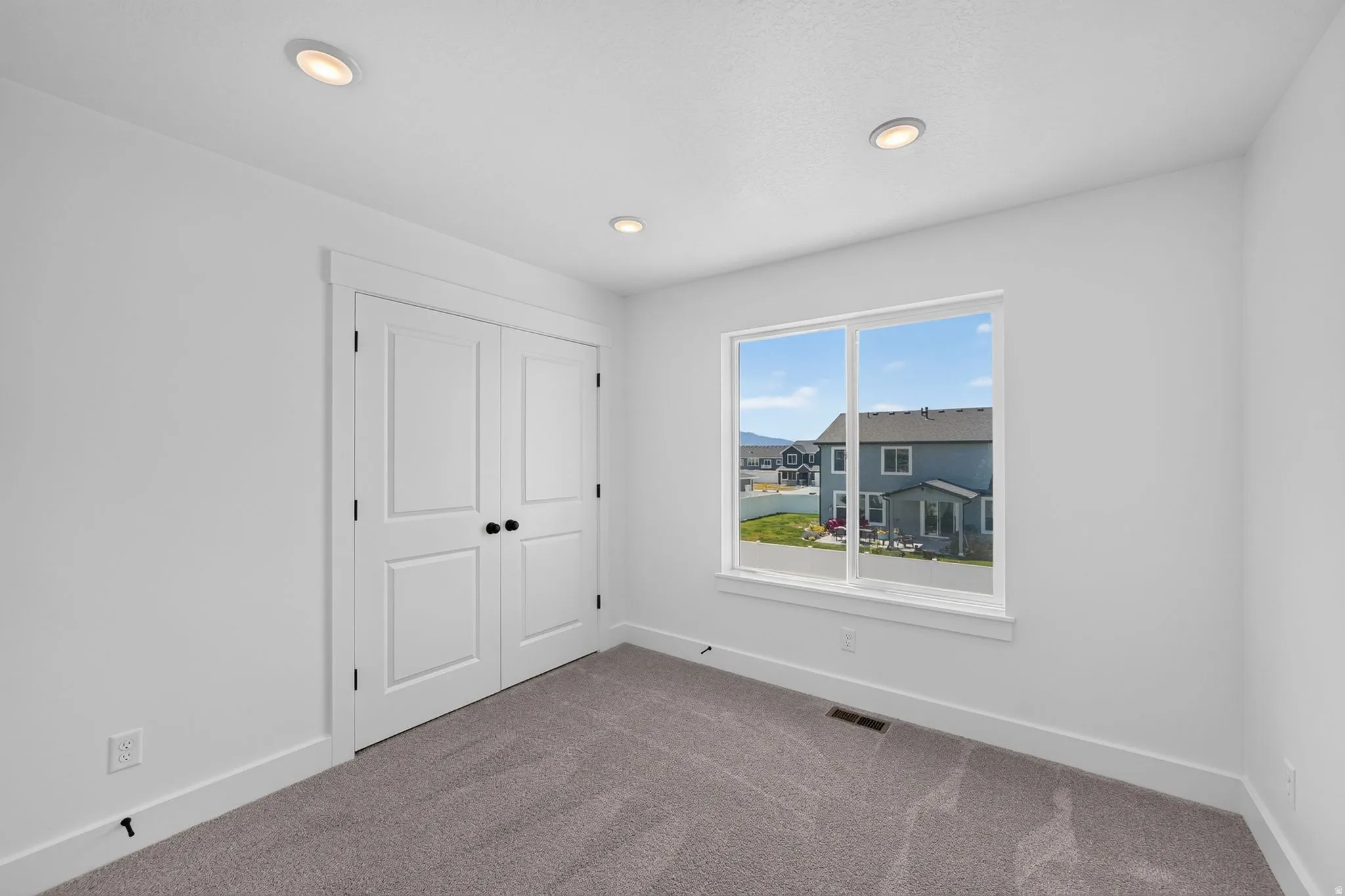 Bedroom 3 Neutral white walls with recessed ceiling lighting
