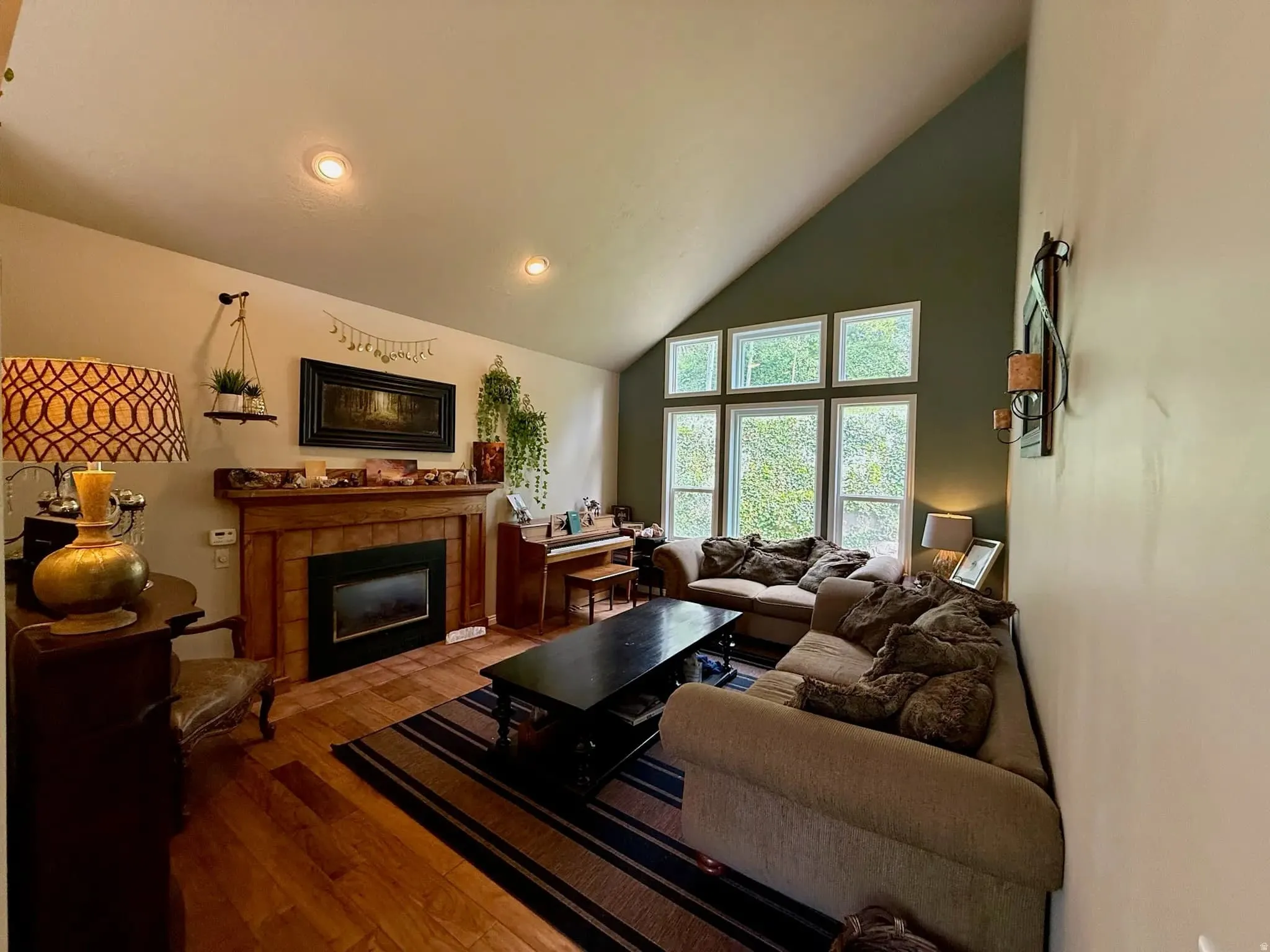 Living area featuring wood-finish flooring, a fireplace with a wood mantel, recessed lighting, and a vaulted ceiling