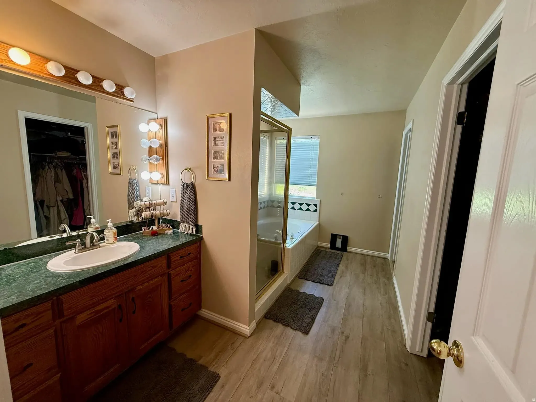 Bathroom featuring a wood-finish vanity with a green countertop and an integrated sink