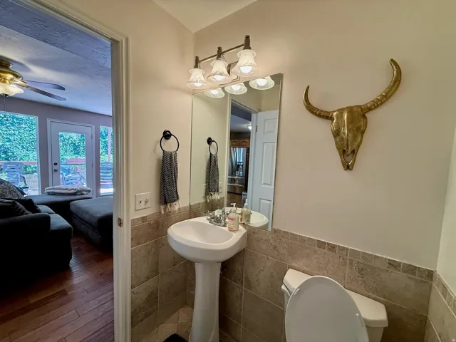 Pedestal sink with tiled wainscoting and coordinating floor tiles