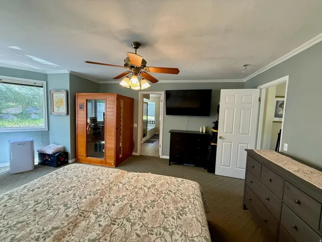 Bedroom featuring a ceiling fan with integrated lighting, wood-finish flooring, and light blue wall paint