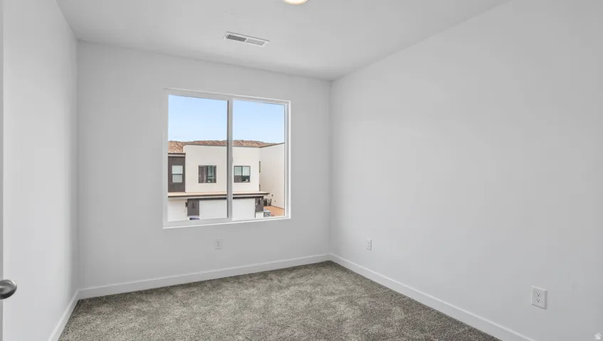 Neutral interior space featuring light gray carpeting, white walls, and white trim