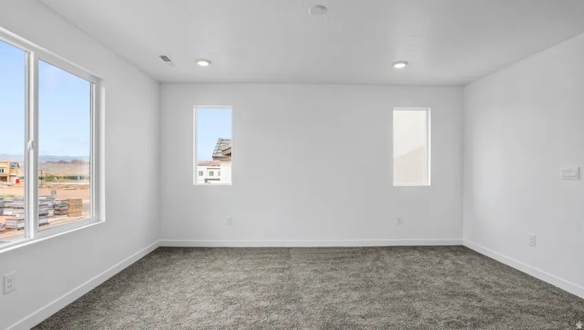 Spacious room featuring neutral carpeting and white baseboards