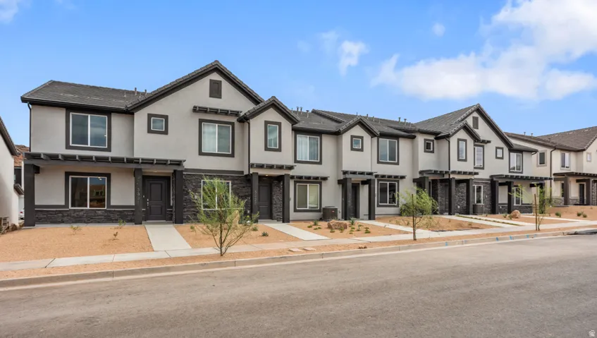 Modern townhome row featuring multi-tone stucco and dark stone veneer accents