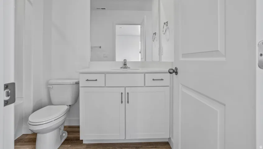 Bathroom featuring a white vanity with cabinet storage, a rectangular undermount sink, a chrome faucet, and a large wall-mounted mirror