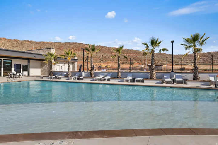 Outdoor swimming pool with an integrated shallow entry area, surrounded by a concrete deck