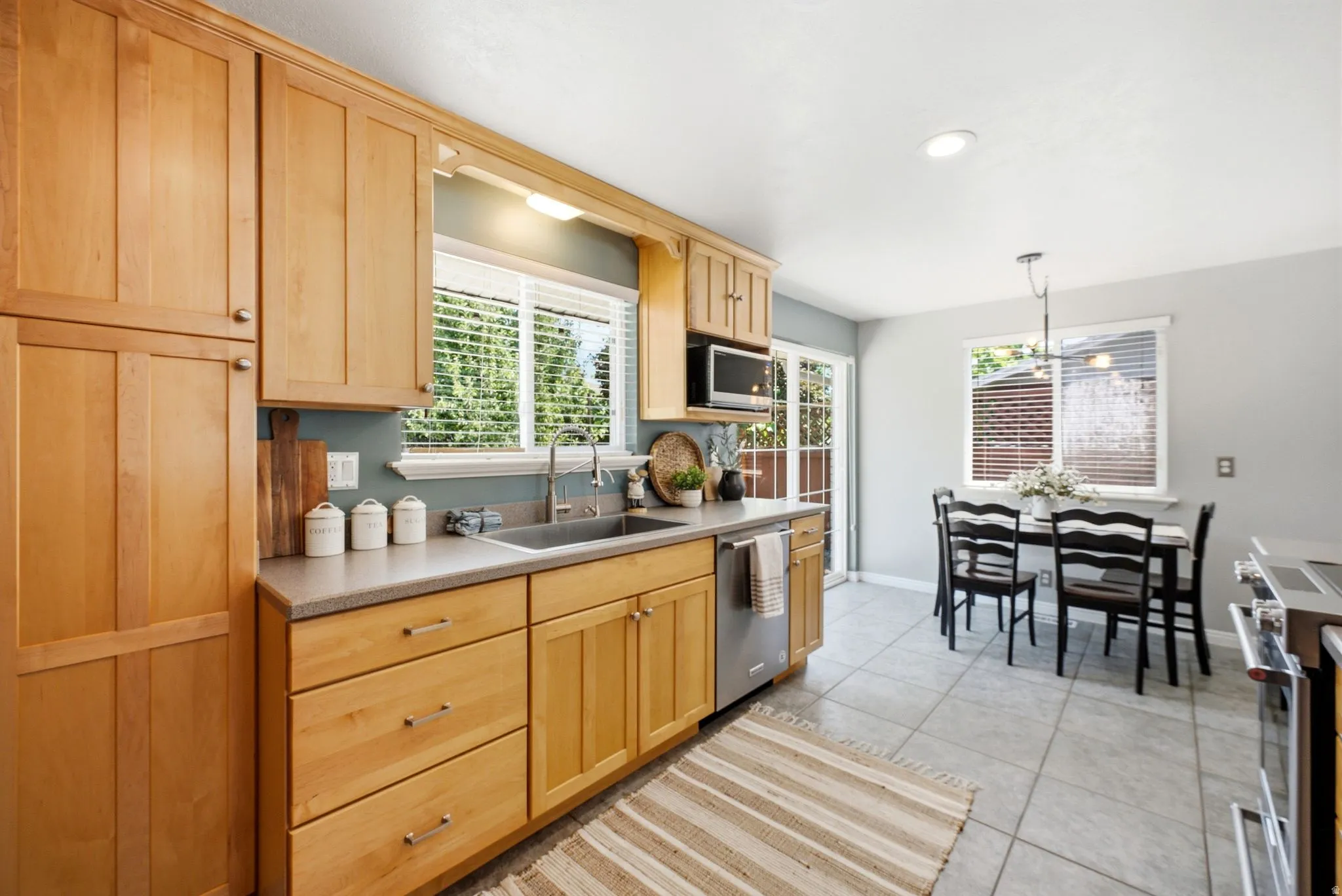 Kitchen featuring natural wood cabinetry, light grey countertops, a stainless steel undermount sink, and recessed lighting