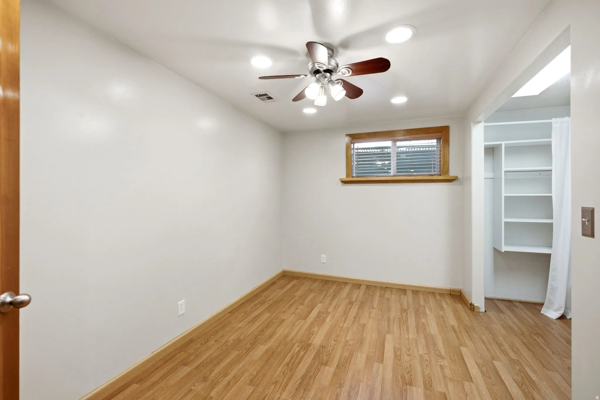 Room featuring wood-finish flooring, recessed lighting, and a ceiling fan with integrated light fixture