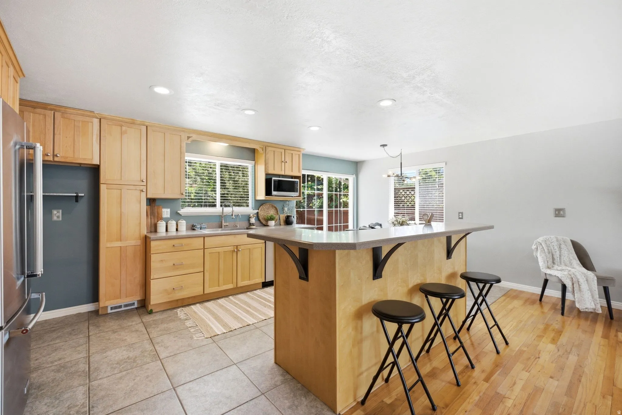 Kitchen featuring light wood cabinetry and a stainless steel refrigerator