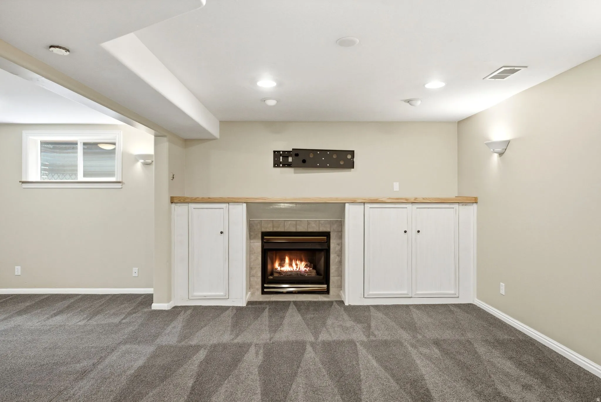 Built-in fireplace with tile surround, wood mantel, and integrated cabinetry