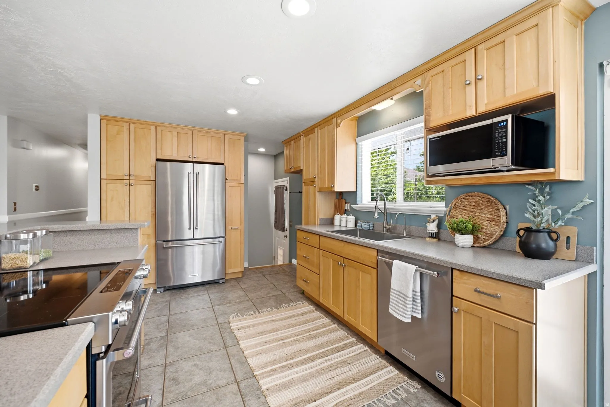Kitchen featuring wood cabinetry, stainless steel appliances, and grey countertops