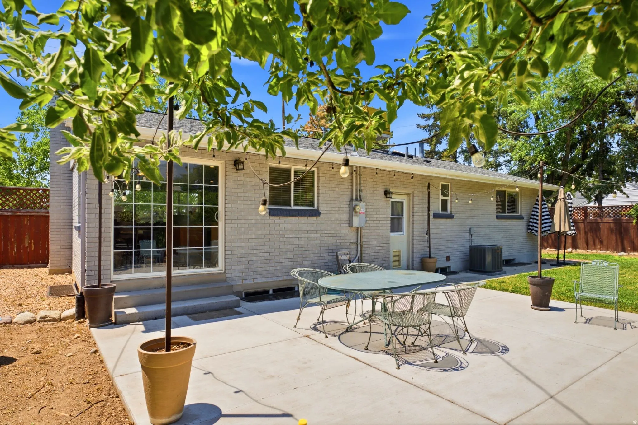Concrete patio with brick exterior and sliding glass door