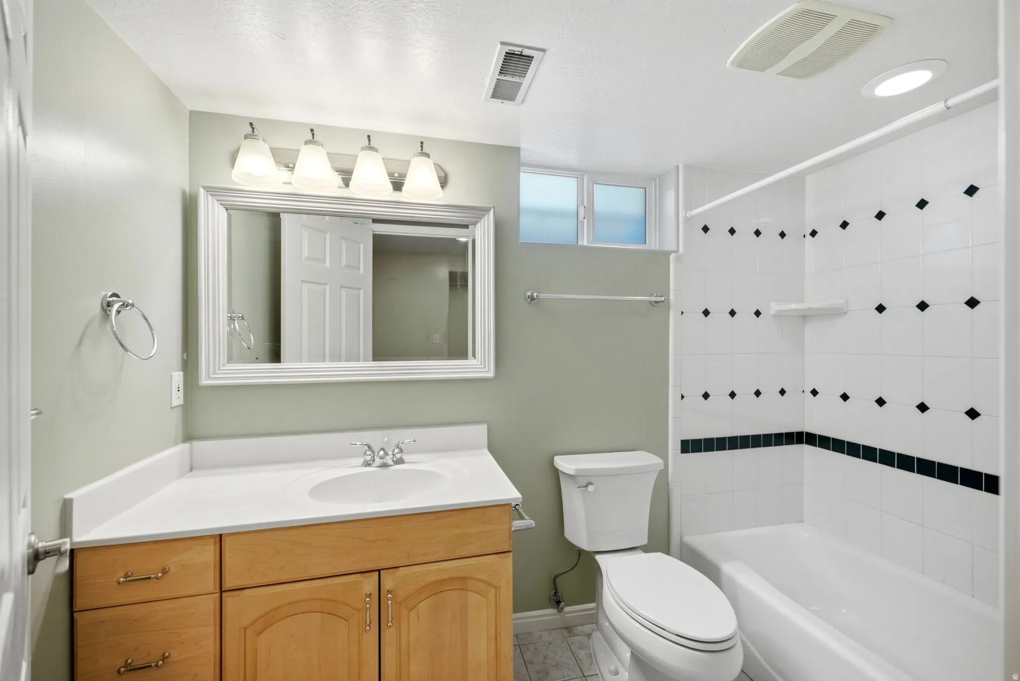 Basement Full bathroom featuring a single vanity with wood cabinetry, a white countertop, and an integrated sink