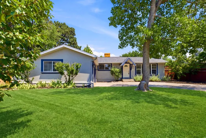 Exterior featuring a gray stucco finish, white trim, and dark blue window accents