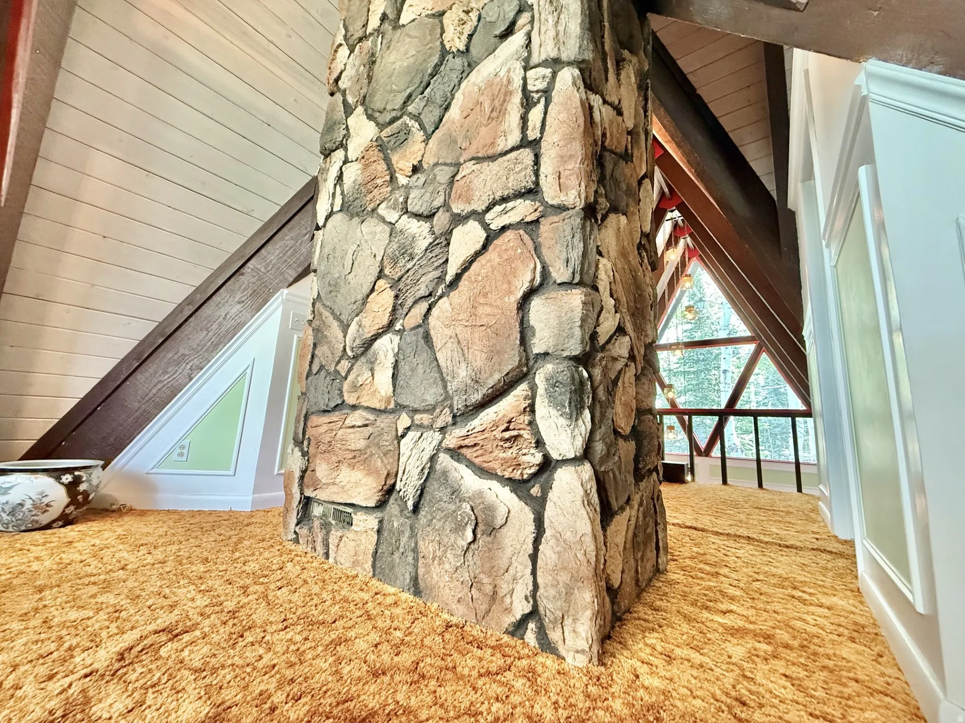 Stone-clad column with exposed beams and an attic window
