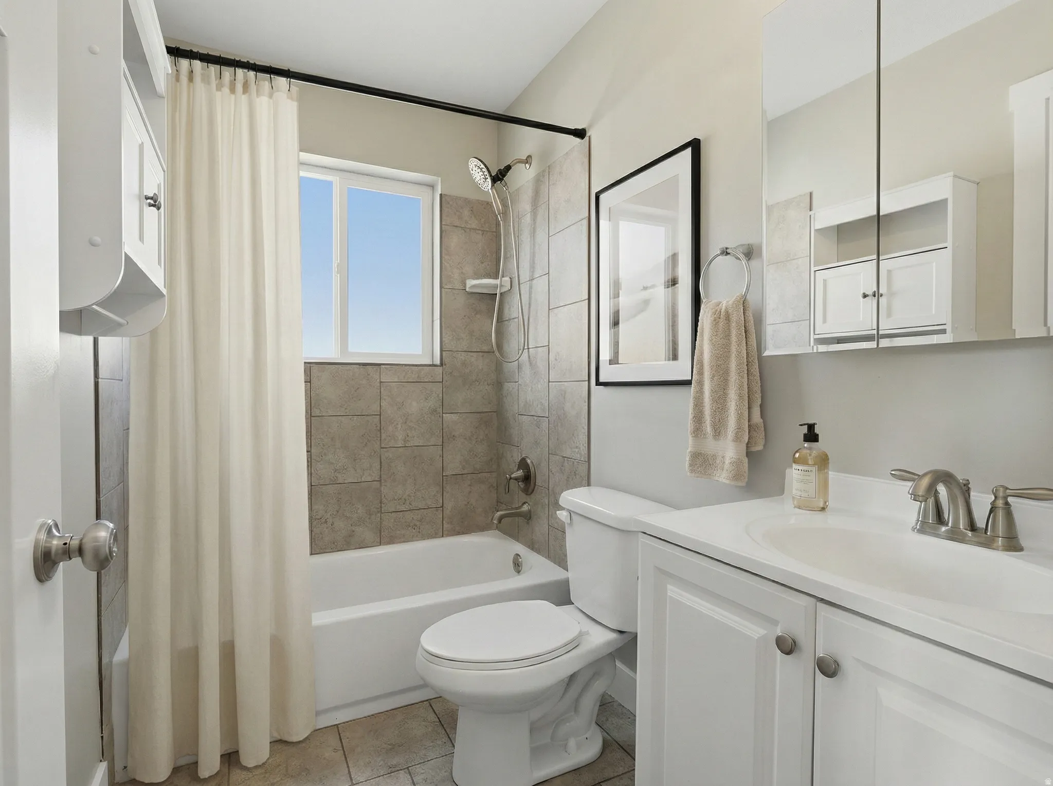 Bathroom featuring a white vanity with built-in sink, brushed nickel faucet, and a large mirrored medicine cabinet