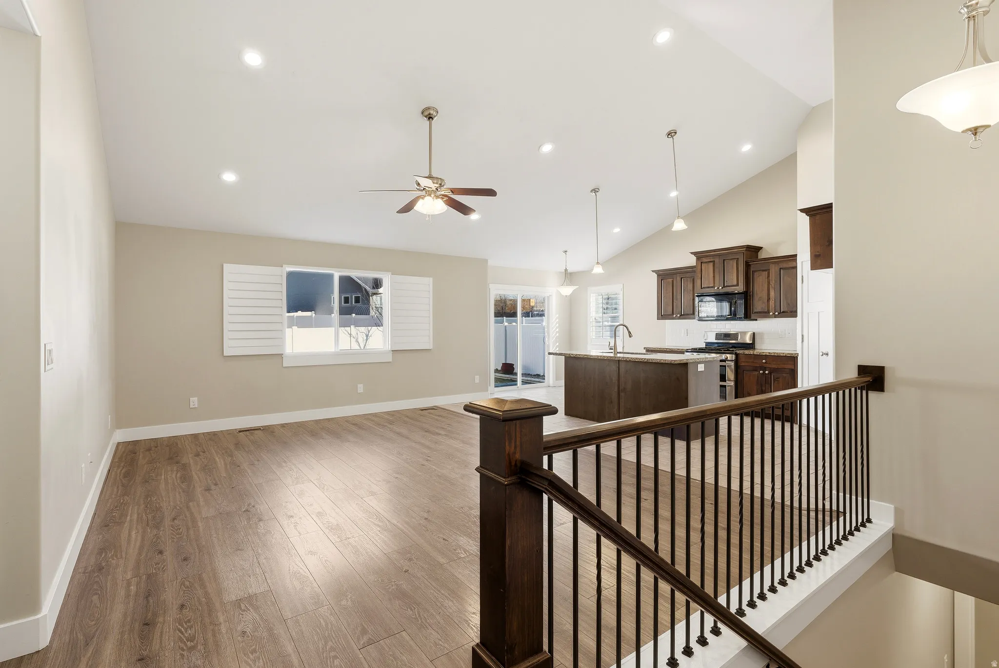 Vaulted ceilings enhance the open-concept living space, featuring LVP flooring, natural light and recessed lighting