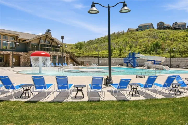 Expansive outdoor pool area featuring a large central pool, water slide, and an adjacent building with prominent architectural features
