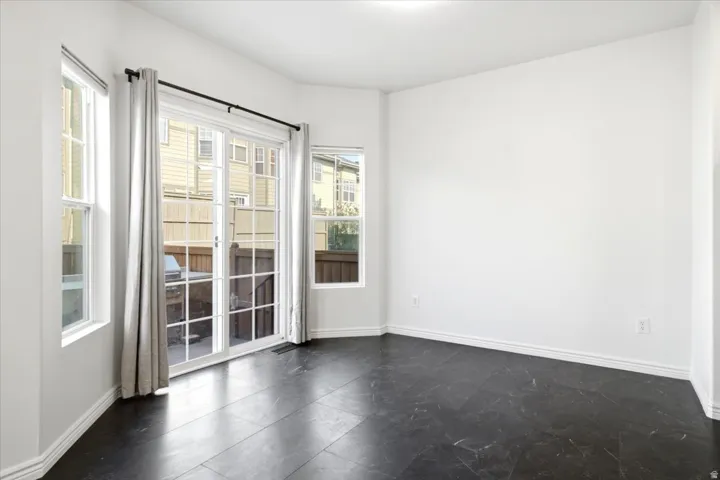 Bright interior space featuring a sliding glass door with muntins, flanked by two single-hung windows