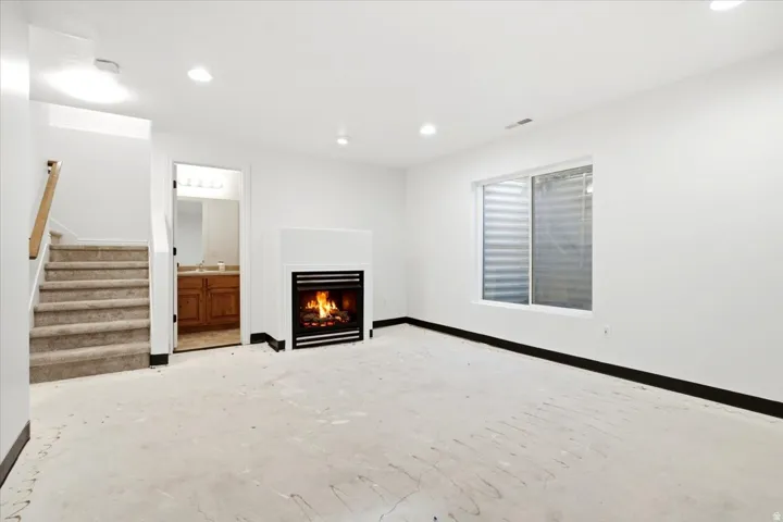 Interior space with a contemporary fireplace, recessed lighting, and a window