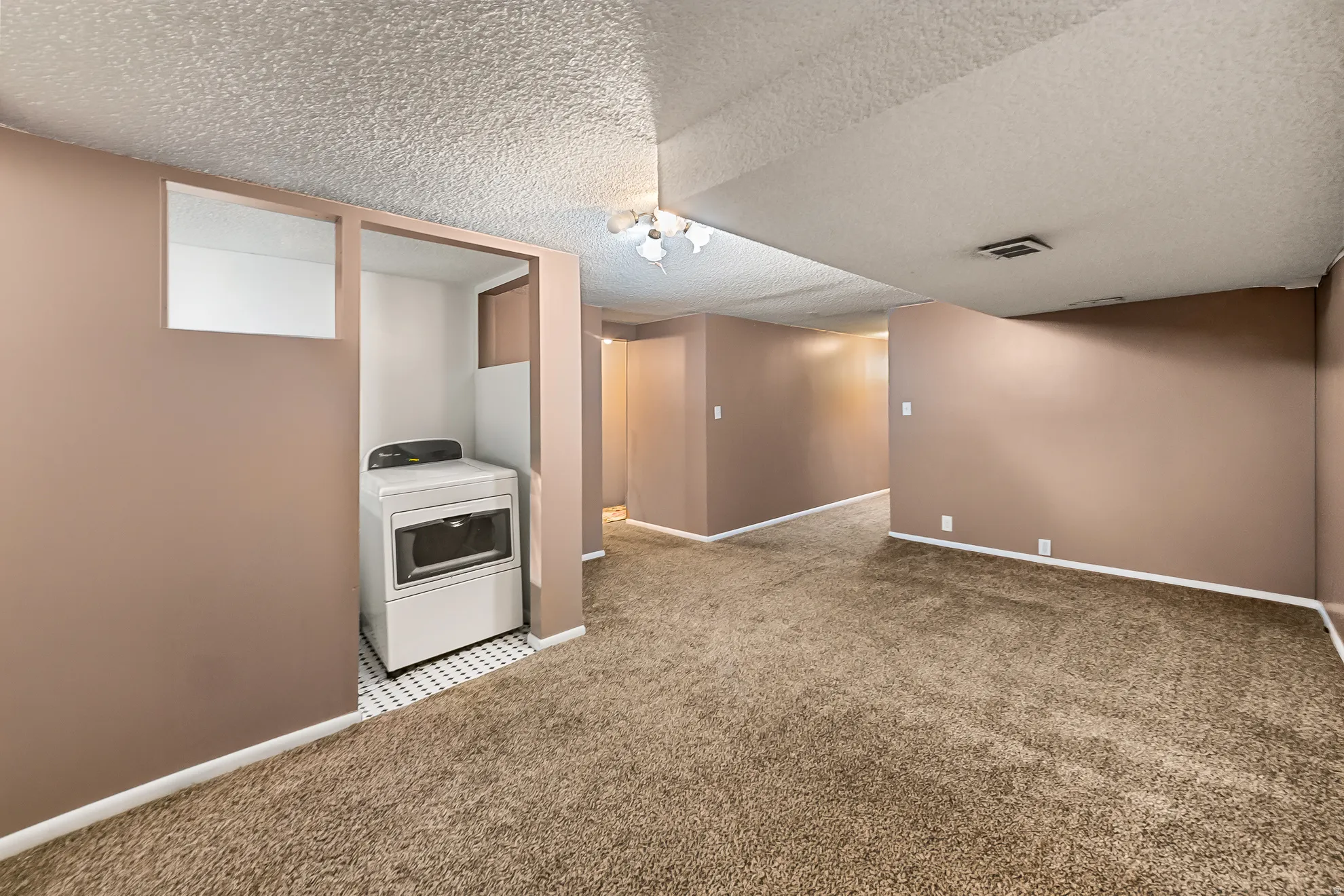 Dedicated laundry alcove with patterned tile flooring