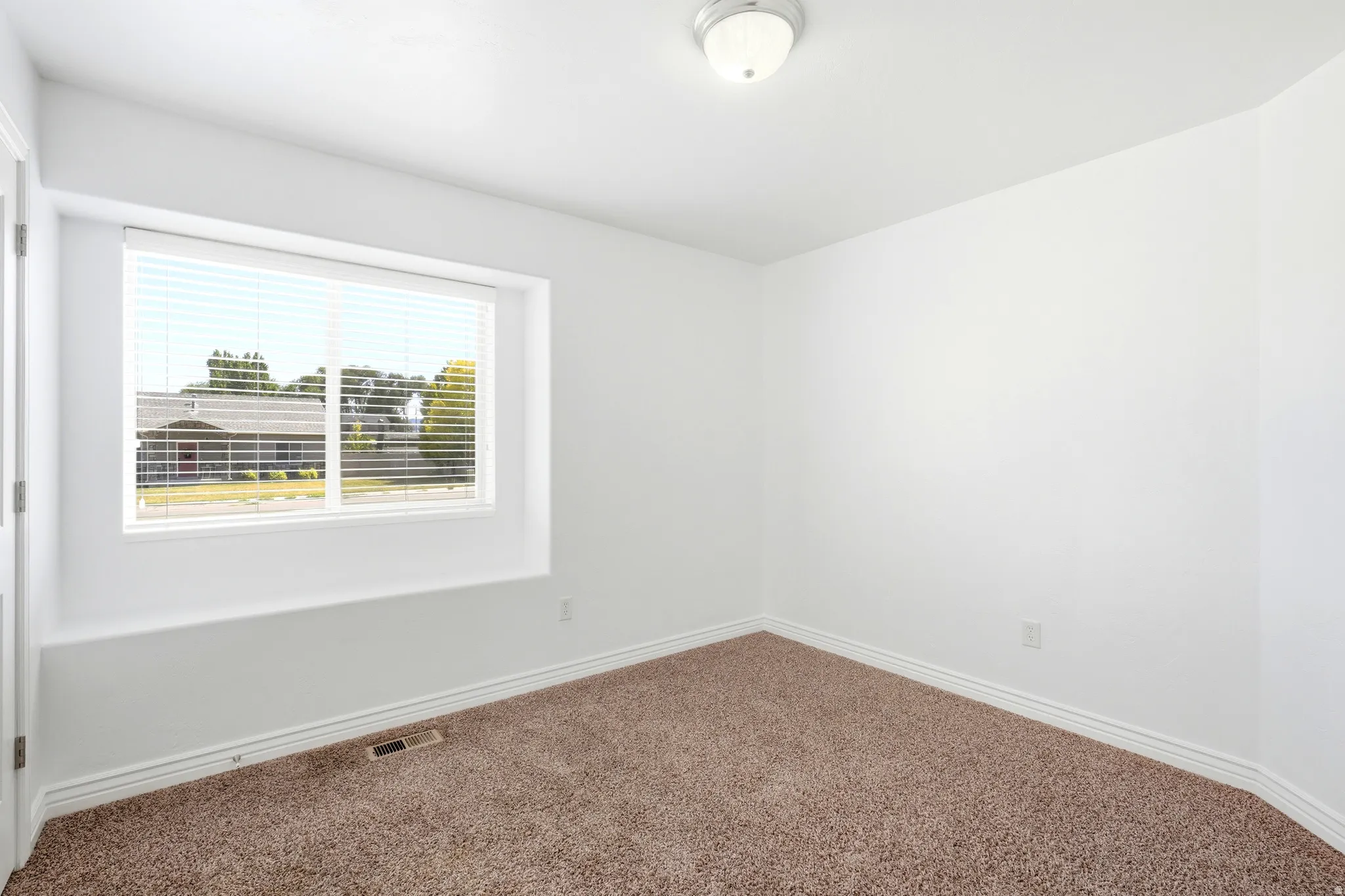 Neutral tone wall finishes with a window featuring horizontal blinds