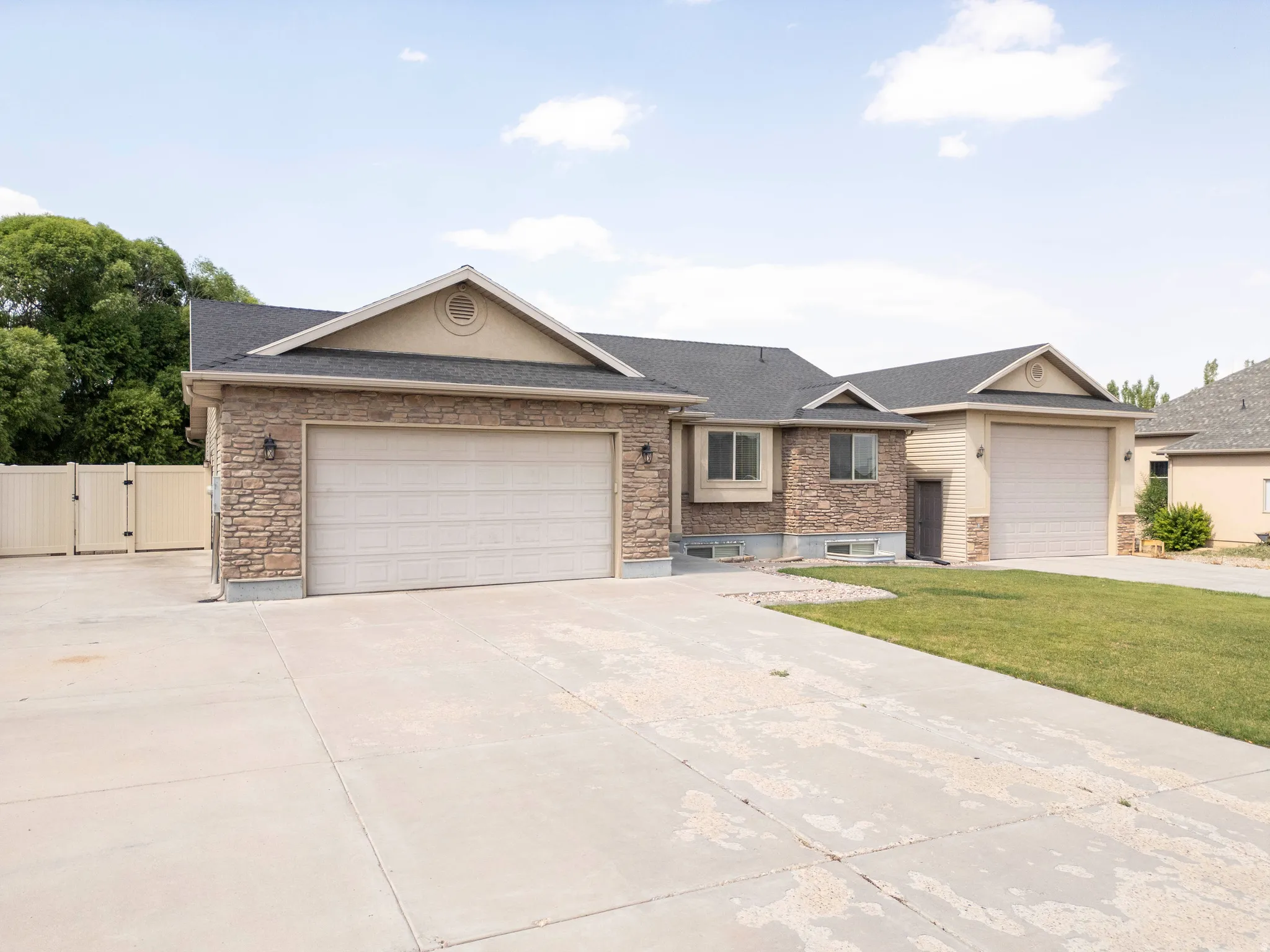 Stone veneer facade with tan siding accents