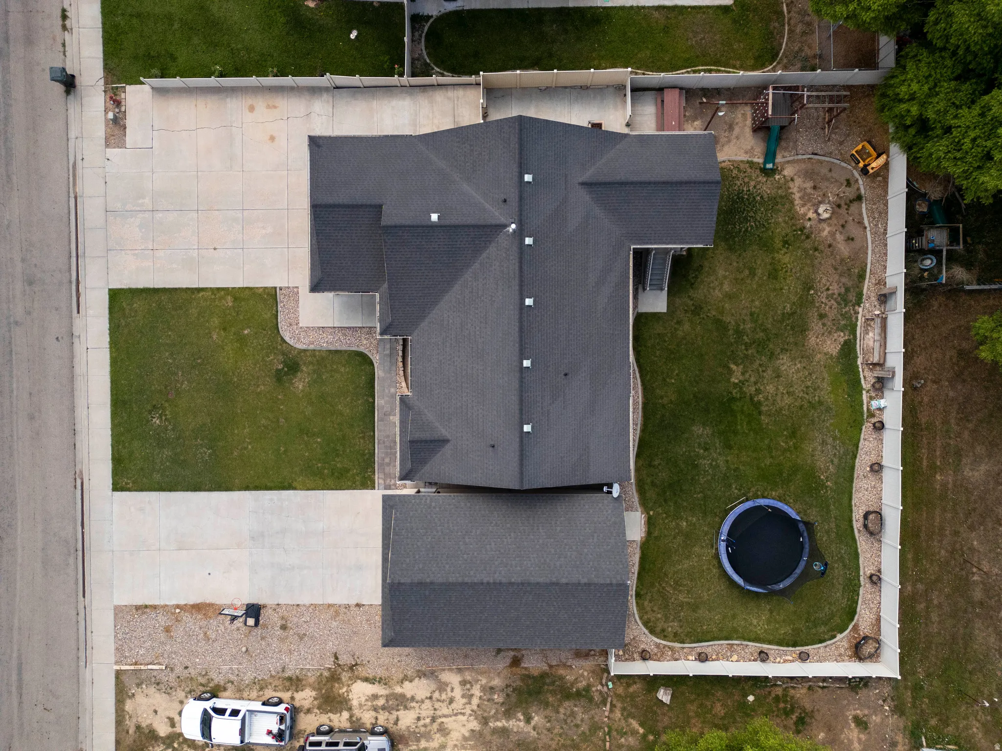 Expansive property with a dark shingle roof and a spacious concrete driveway