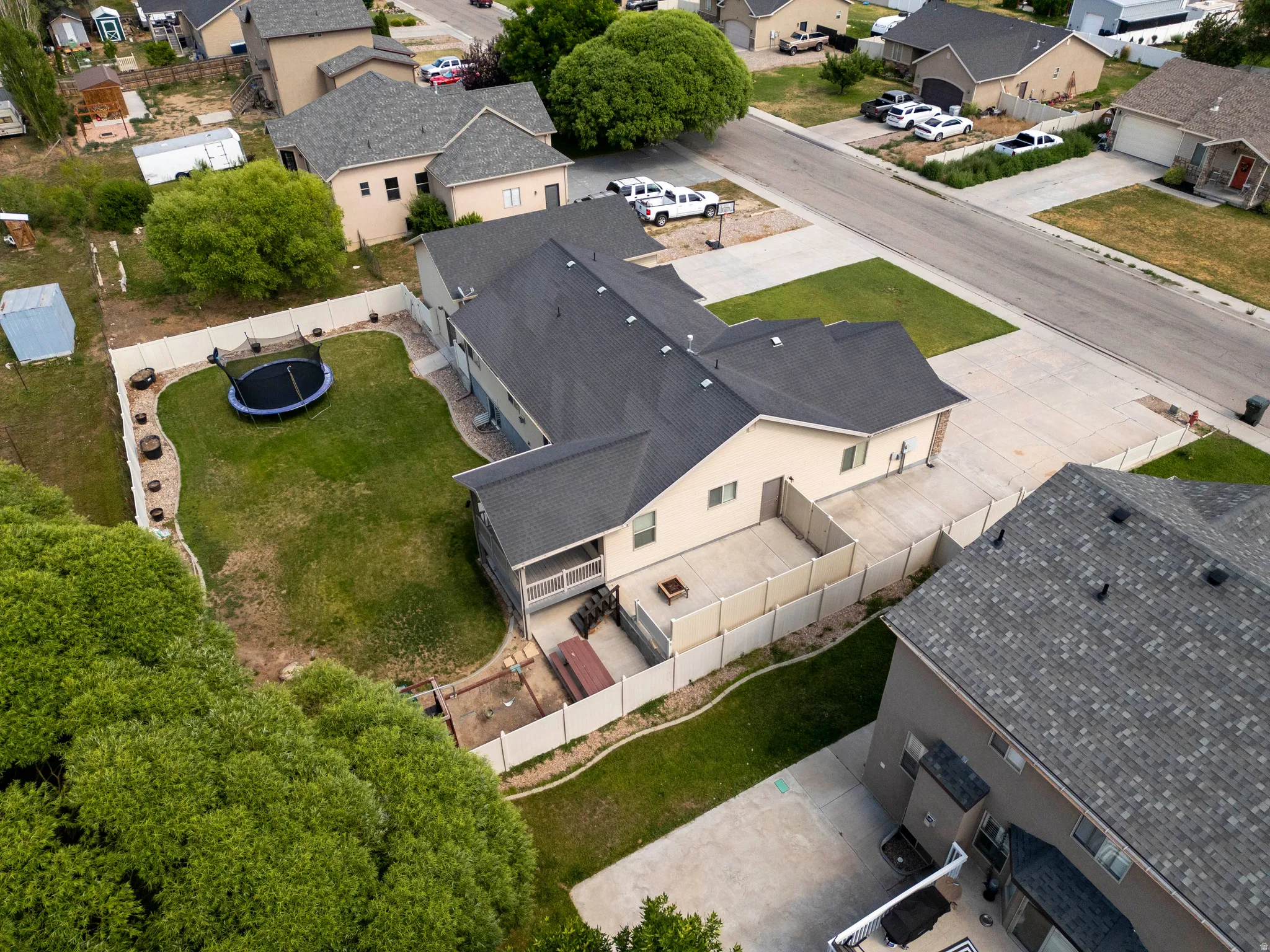 Spacious backyard featuring a large green lawn and a perimeter fence