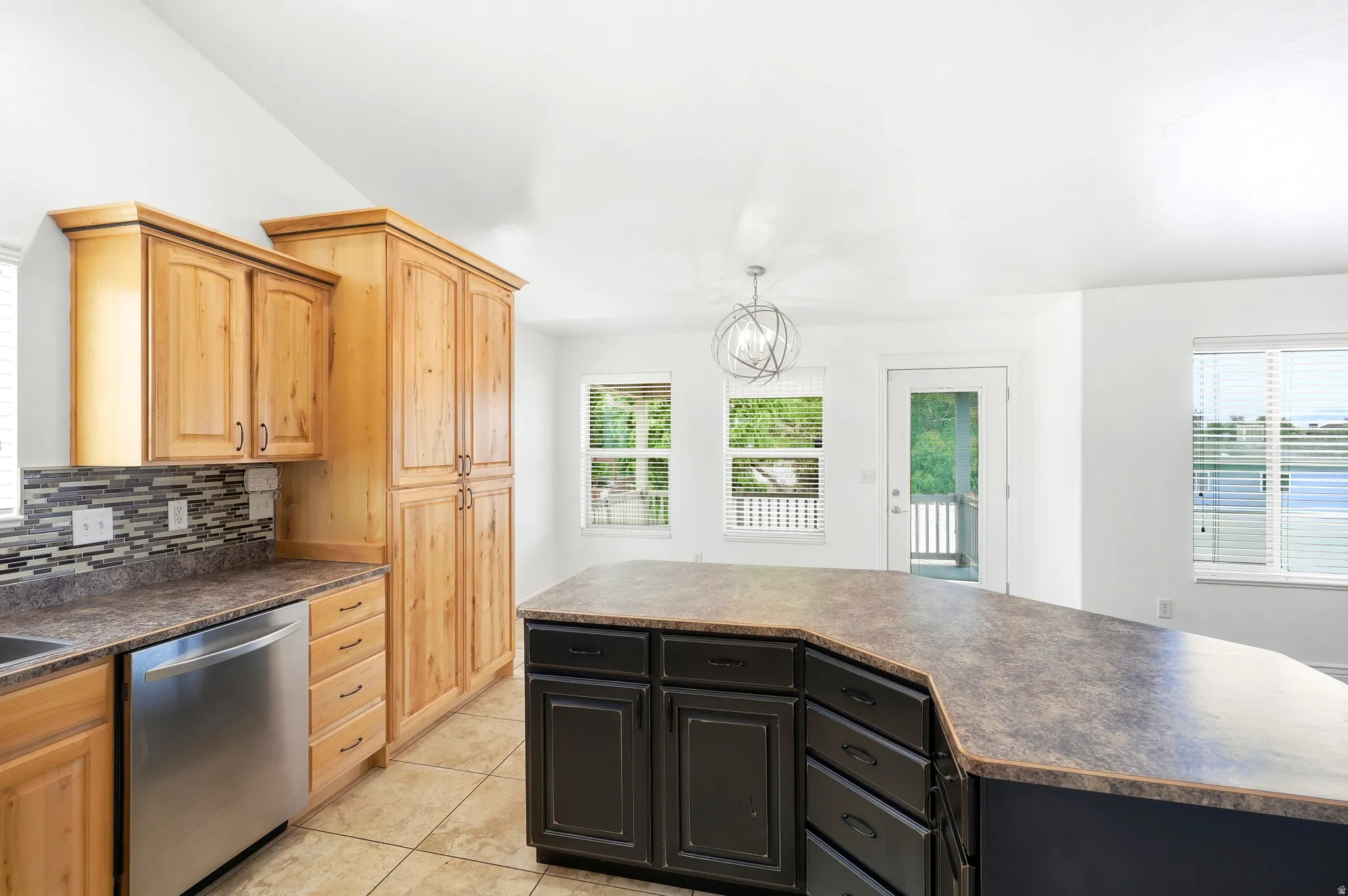 Kitchen featuring light wood cabinetry, a mosaic tile backsplash, and stainless steel appliances