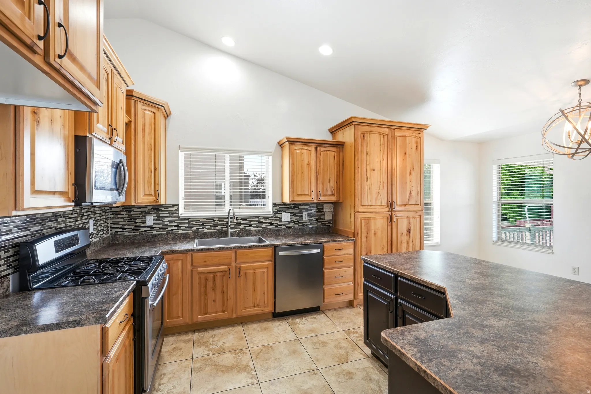 Kitchen featuring wood cabinetry, stainless steel appliances, and a mosaic tile backsplash