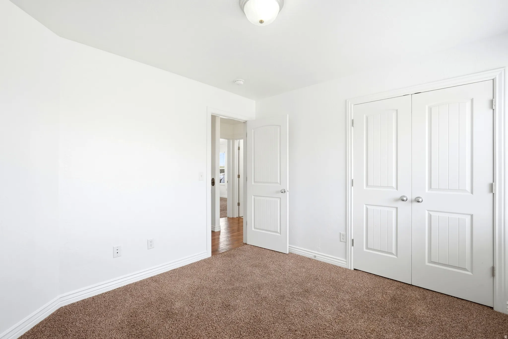 Bedroom featuring brown carpet flooring, white painted walls, and white baseboards