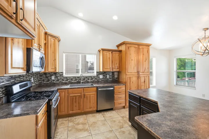 Kitchen featuring wood cabinetry, stainless steel appliances, and a mosaic tile backsplash