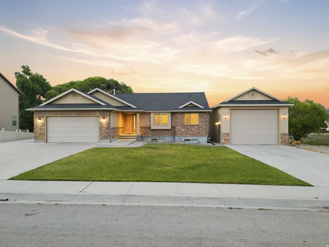 Ranch-style exterior featuring stone and stucco finishes, a dark shingle roof, and multiple gables